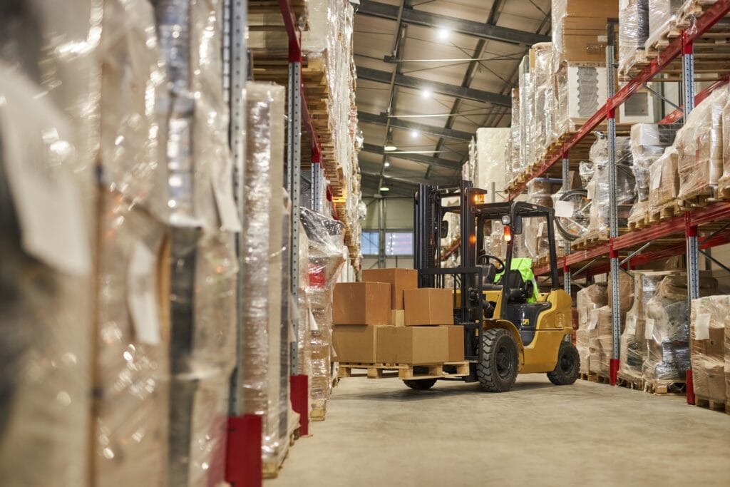 Efficient warehouse with forklift handling boxed inventory for logistics and storage solutions.
