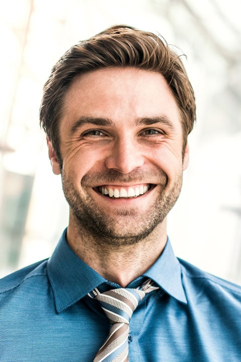 Confident business professional smiling, modern office background, corporate success.