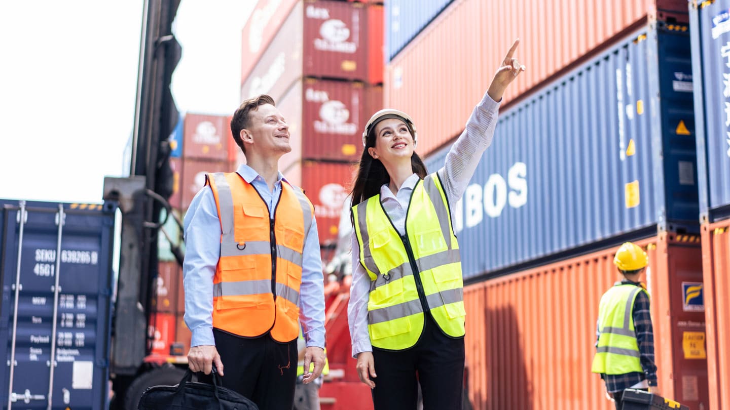 1. Factory workers inspecting shipping containers at a logistics yard.