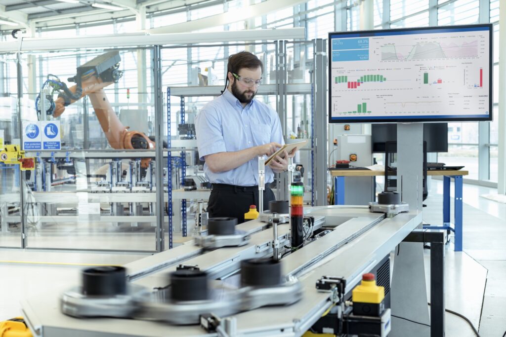 Innovative industrial automation with robotic arms and data analytics in a high-tech factory.