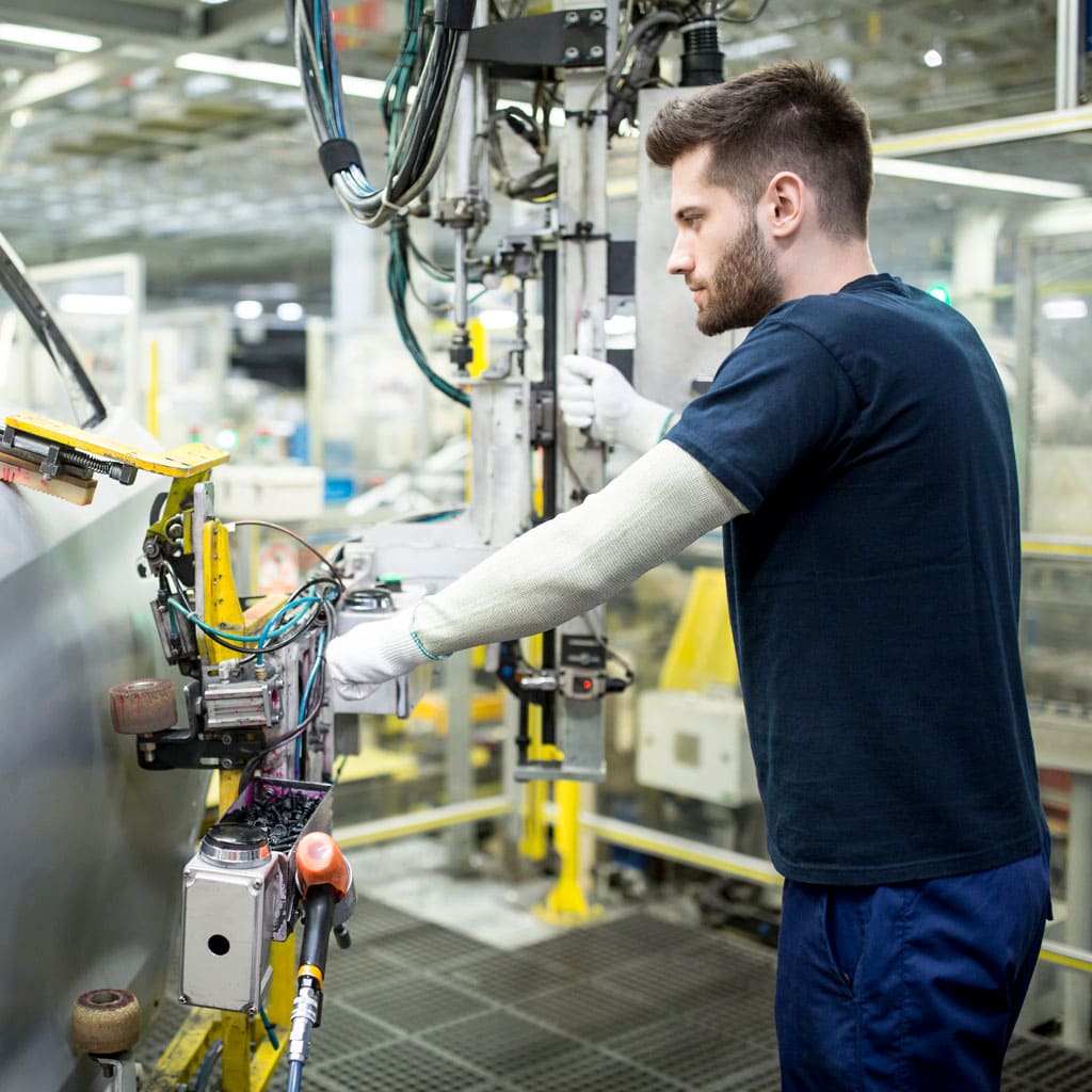 Precision industrial machinery technician working on automation system in manufacturing plant.