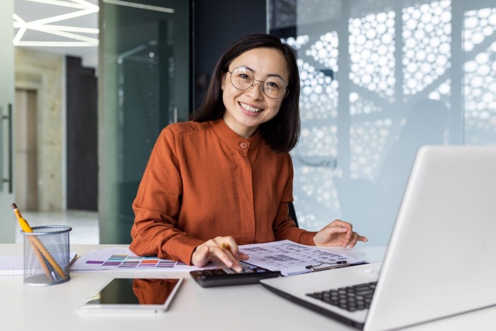 Bright young woman working on graphic design in modern office setting.