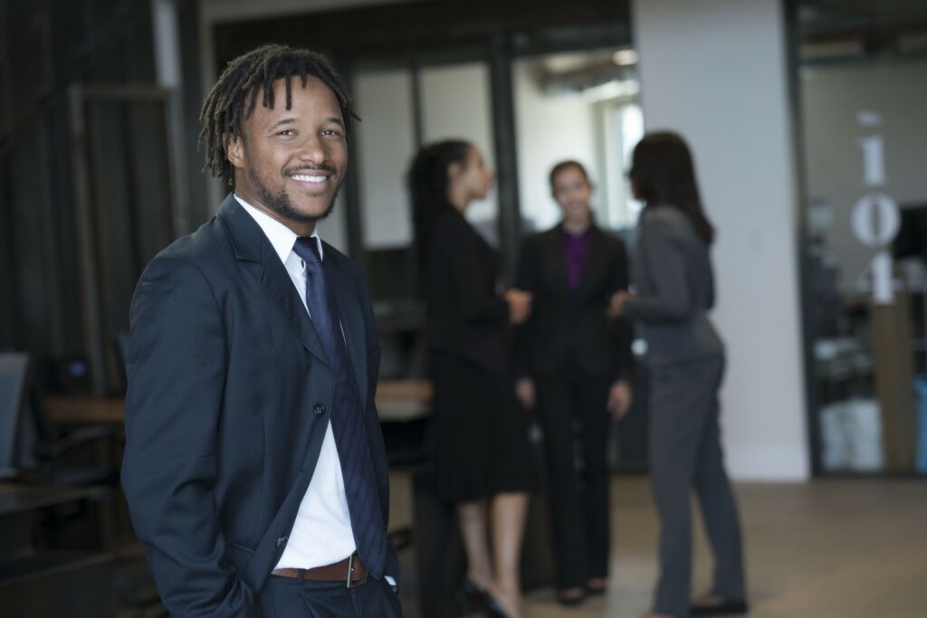 Diverse professional business team socializing in modern office setting.