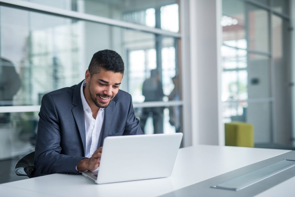 Business professional working on laptop in modern office environment.