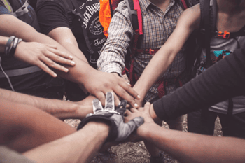 Diverse group of people joining hands for teamwork and collaboration.