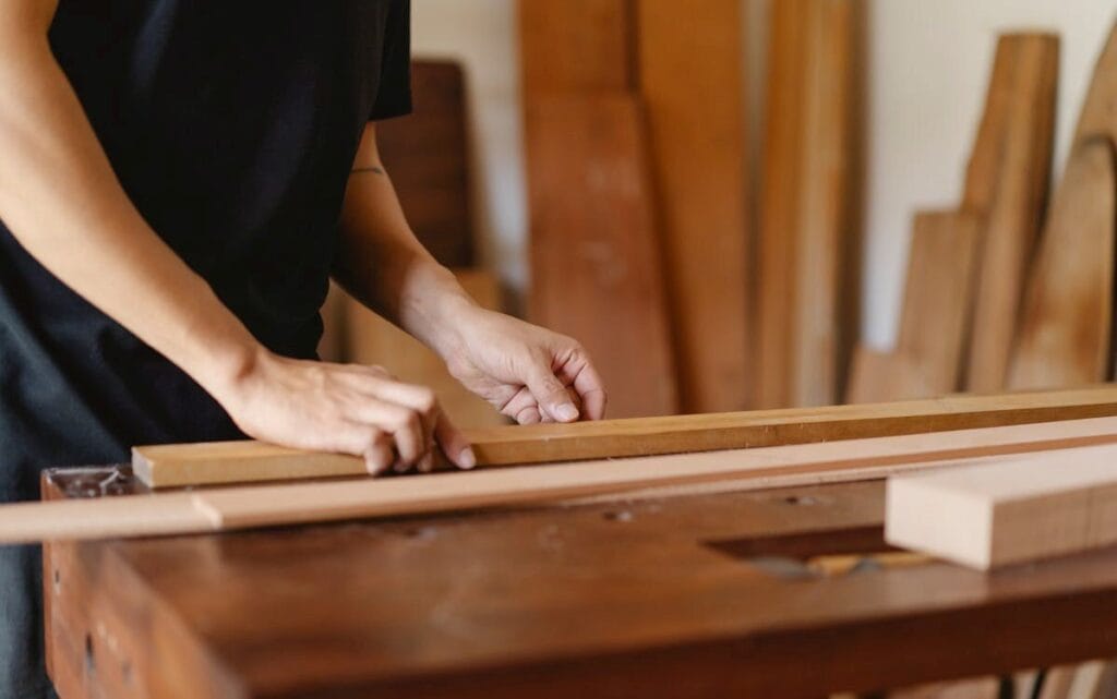 Craftsman working with wood in a woodworking workshop, focused on carpentry and woodworking craftsmanship.