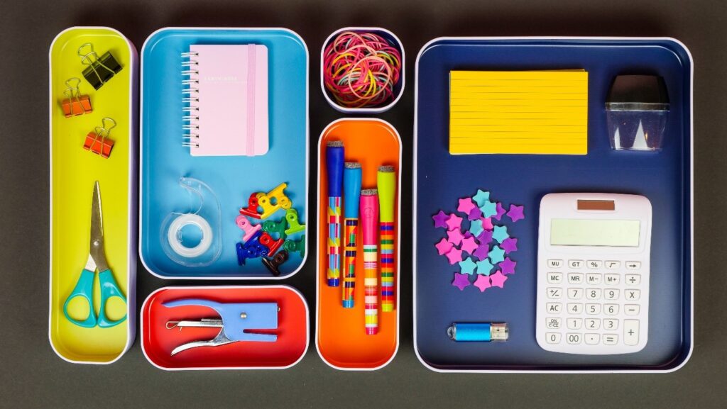 Colorful office supplies organized in a tray for productivity and organization.