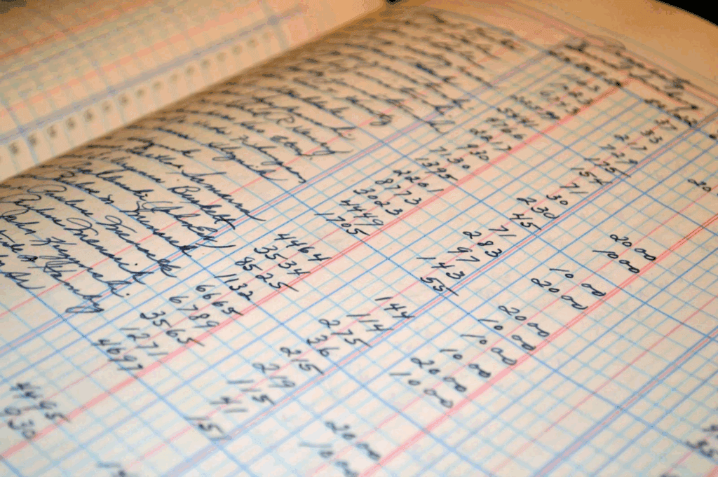 Handwritten financial ledger or accounting records on graph paper for financial management.