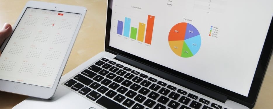 Colorful business charts on laptop and tablet screens for data analysis and financial planning.