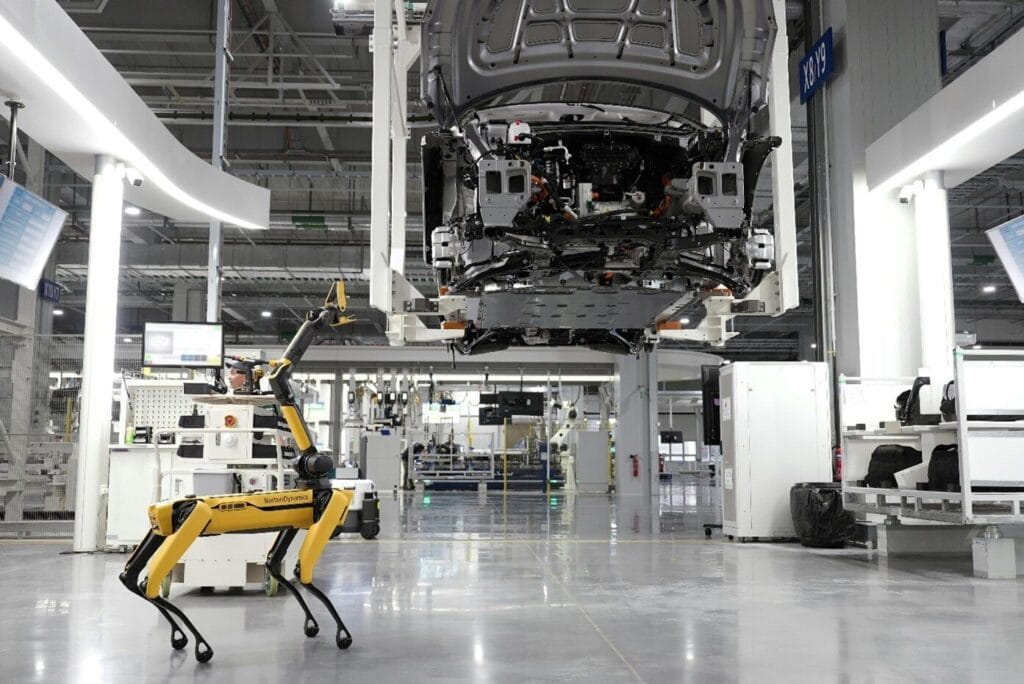 Autonomous robot inspecting automotive assembly line in modern factory.