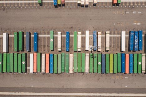 Colorful container trucks parked in a logistics yard for freight transportation.