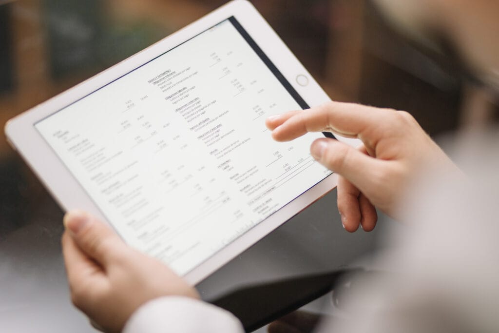 A person viewing a digital invoice or financial document on a tablet screen.