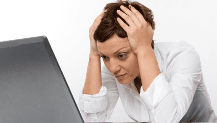 Overwhelmed woman stressed at her laptop, representing work or concentration challenges.