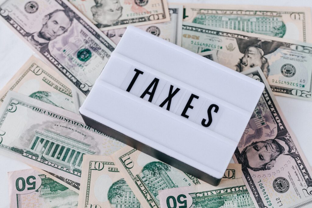 Tax preparation concept with US dollar bills and illuminated box saying "TAXES".