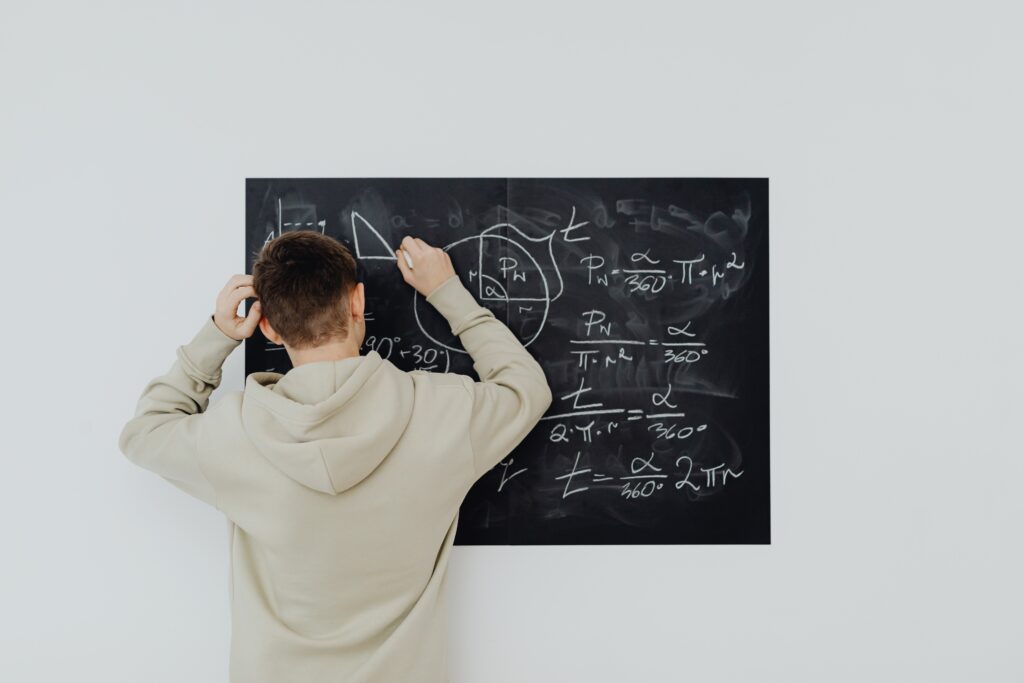 Complex scientific formulas written on a black chalkboard in a classroom setting.