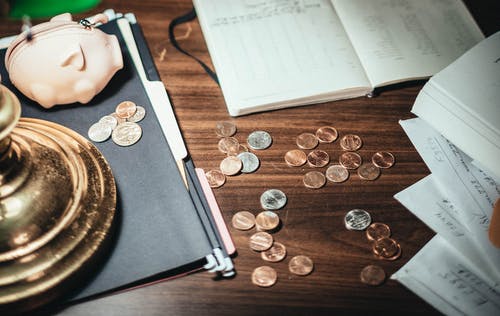 Coins and financial documents on a wooden desk, representing financial management and investment planning.