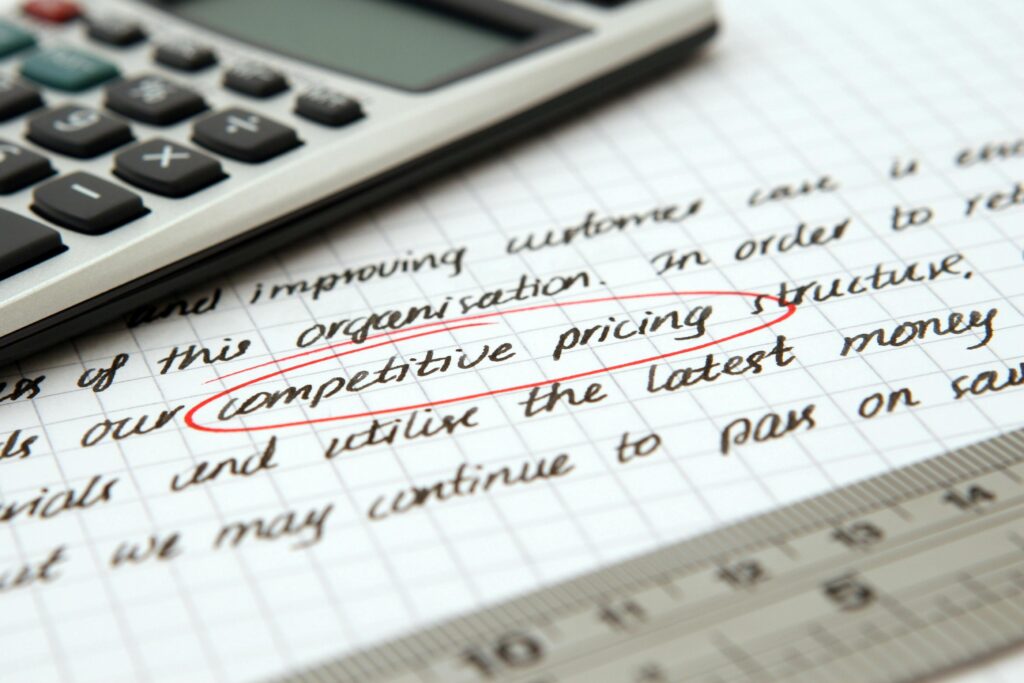Competitive pricing strategy on handwritten notes and calculator for business analysis.