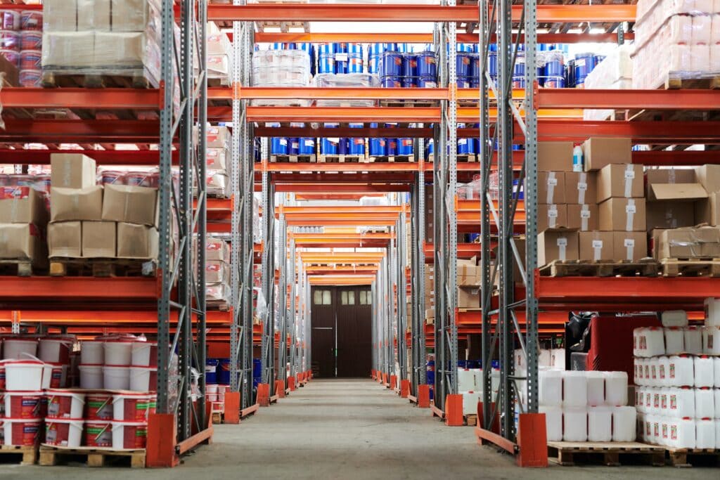 Bright warehouse storage shelves filled with packaging supplies and products, organized for distribution and logistics.