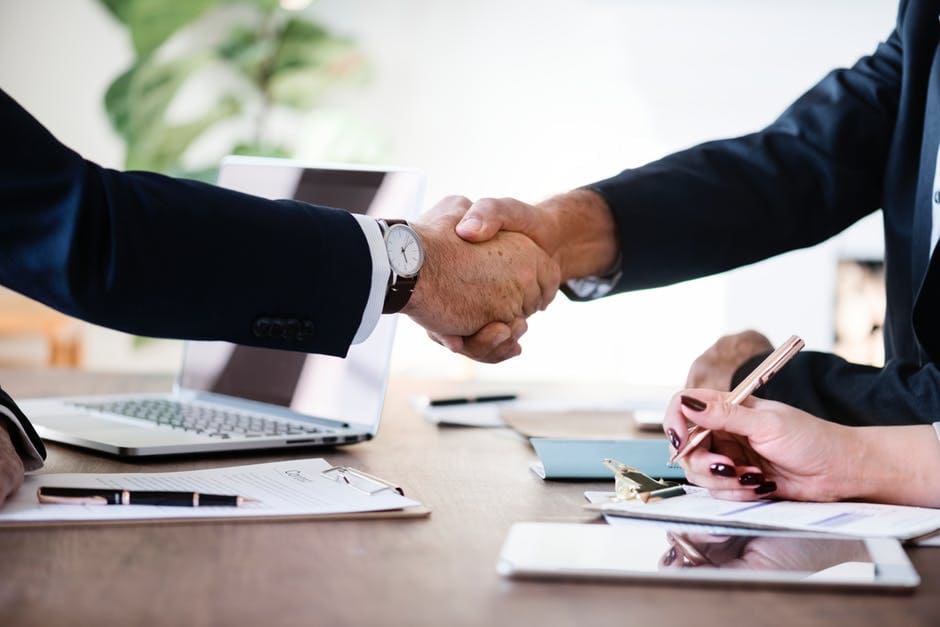 Handshake agreement between business professionals in a modern office setting.