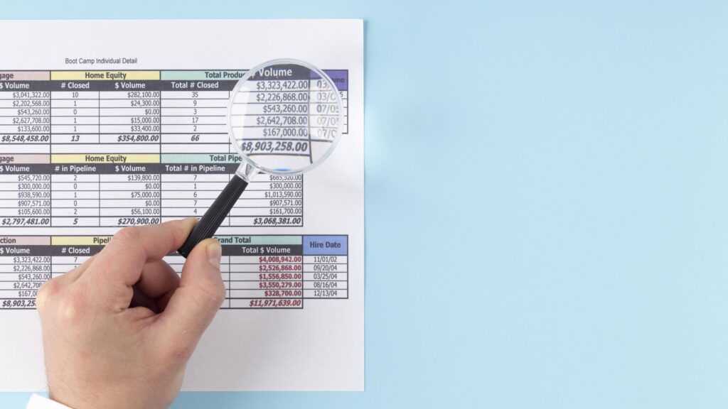 Magnifying glass inspecting financial report with revenue and pipeline data for business analysis.