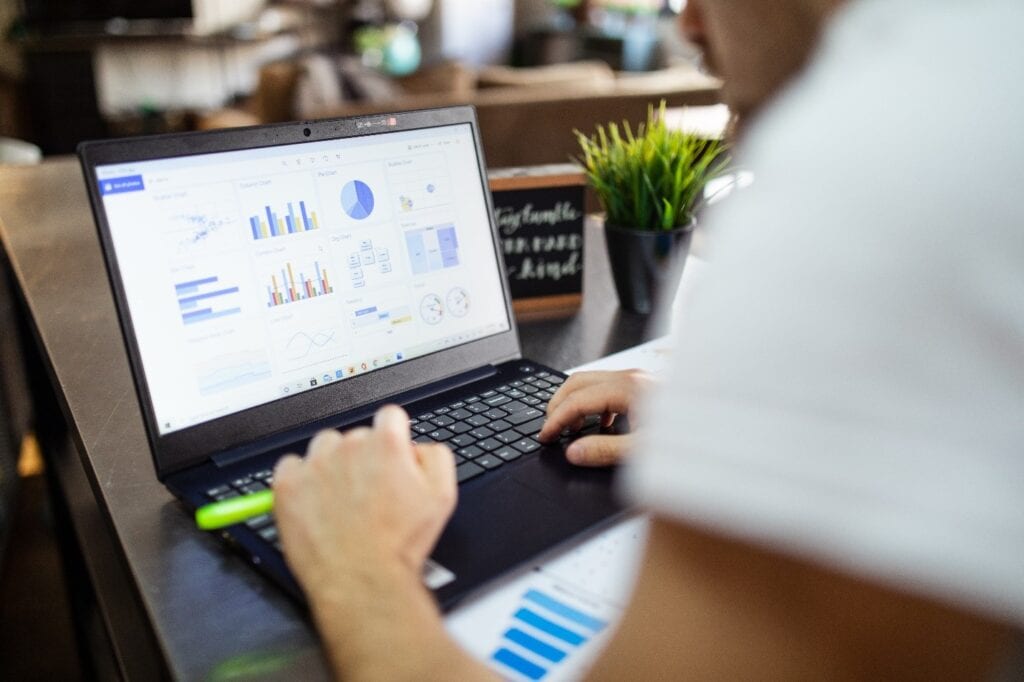Data analytics on laptop screen, business charts, graphs, and reports for data-driven decisions.