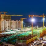 Crane construction site at night, high-rise building, urban development, lighting, construction progress.