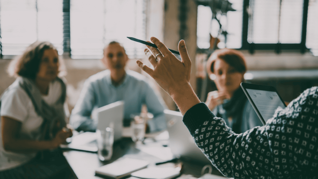 Business team discussing strategies with laptops and tablets in a modern office.