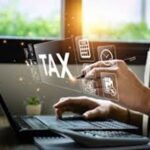 Person entering tax IDs on laptop screen for SuiteTax compliance.