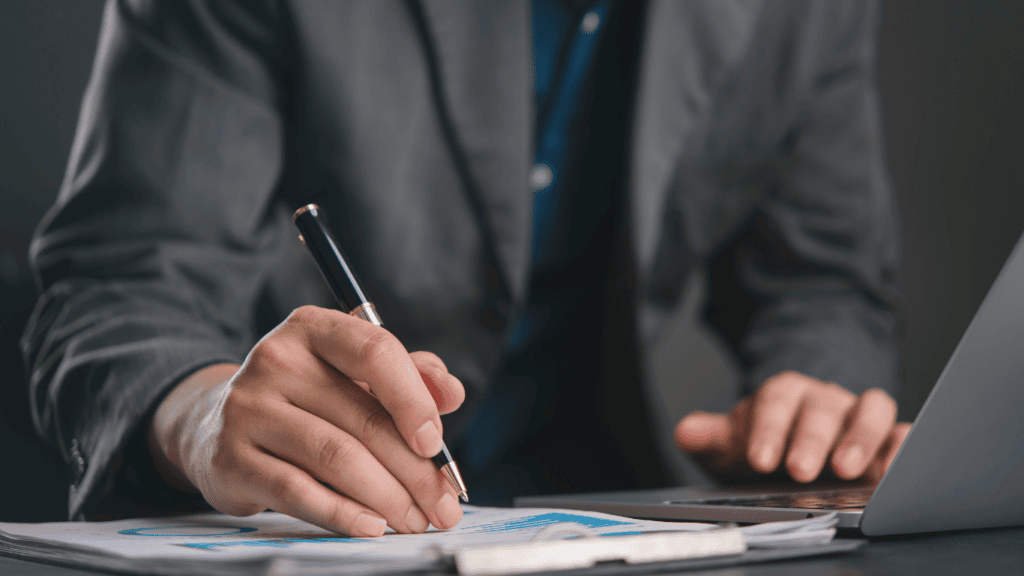 CFO reviewing financial data on paper with laptop, seamless transition from QuickBooks to NetSuite.