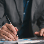 CFO reviewing financial data on paper with laptop, seamless transition from QuickBooks to NetSuite.