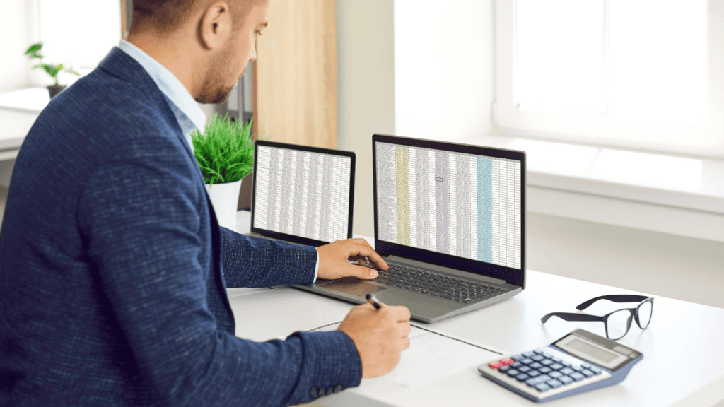 Business professional analyzing financial data on dual monitors for growth.
