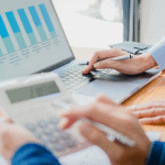 Business professionals analyzing financial data on laptop and calculator for growth insights.
