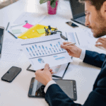 Business professionals analyzing financial data and charts on digital devices.