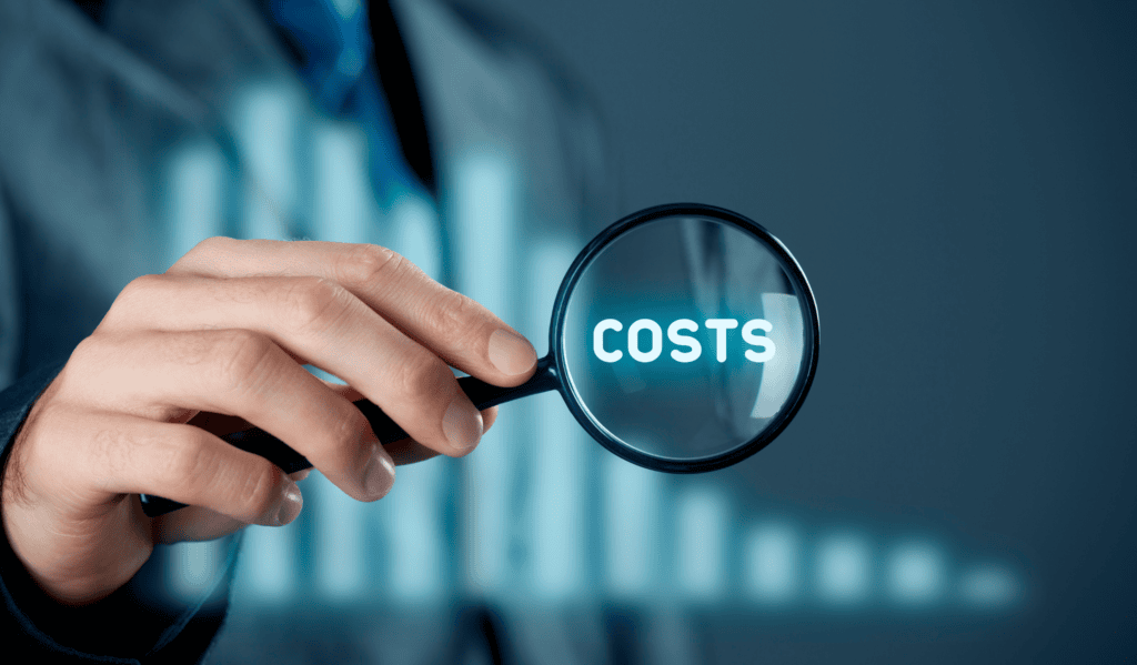 Business professional holding magnifying glass with "COSTS" text, analyzing expenses.