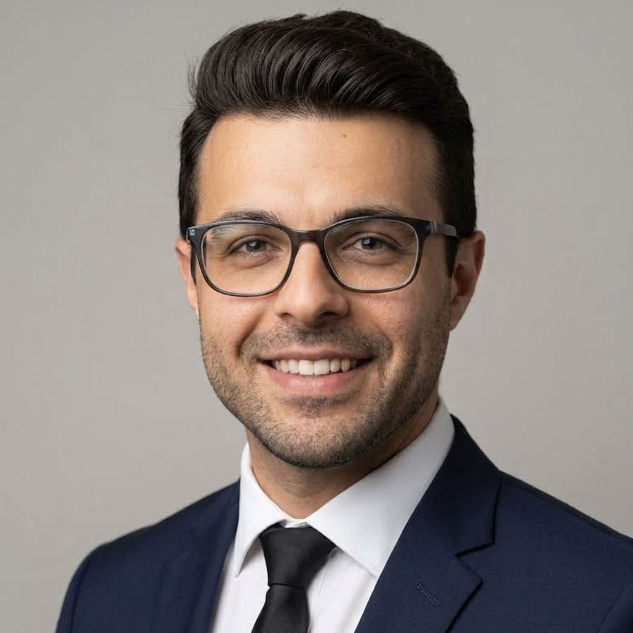 Business professional wearing glasses and suit, smiling confidently.